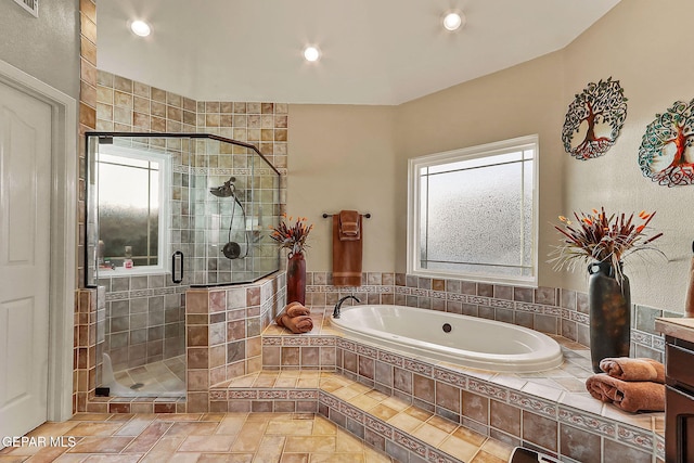 bathroom featuring a wealth of natural light and independent shower and bath