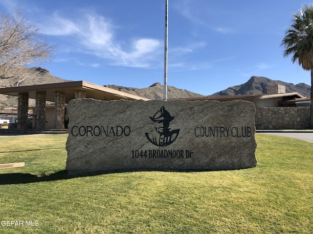 community / neighborhood sign featuring a mountain view and a yard