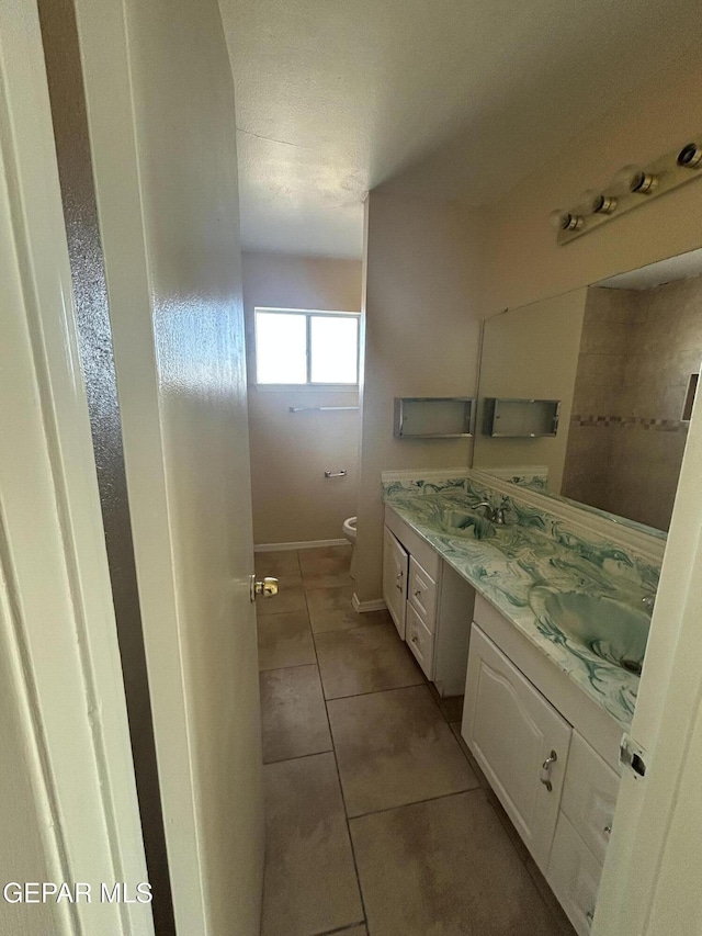 bathroom with tile patterned flooring, vanity, and toilet