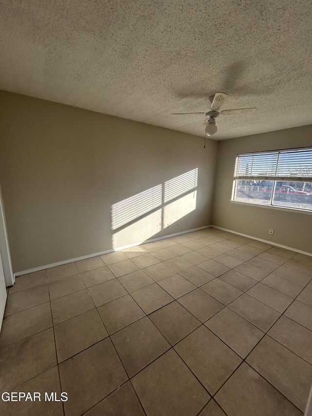 tiled spare room featuring ceiling fan and a textured ceiling