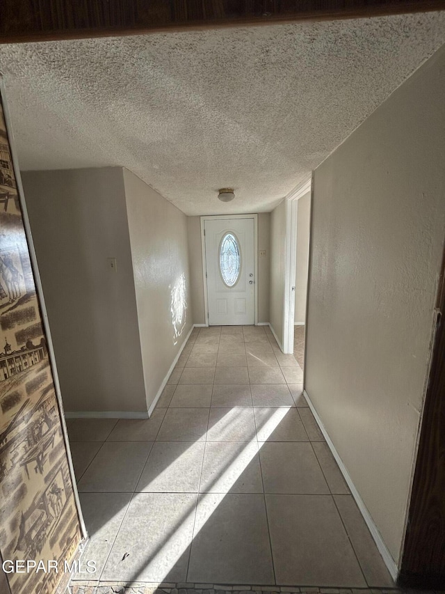 doorway featuring light tile patterned floors and a textured ceiling