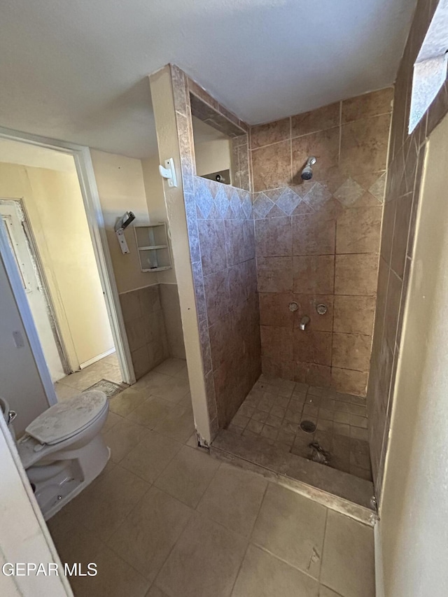 bathroom featuring toilet and tiled shower