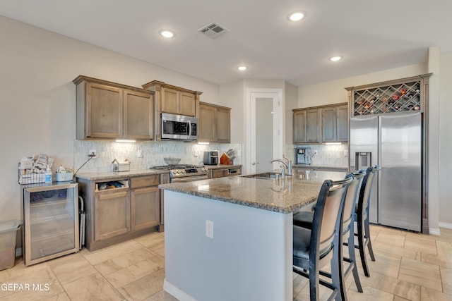 912 Crystal Deer Dr, El Paso, TX 79928 - kitchen with a kitchen island with sink, sink, wine cooler, tasteful backsplash, and stainless steel appliances