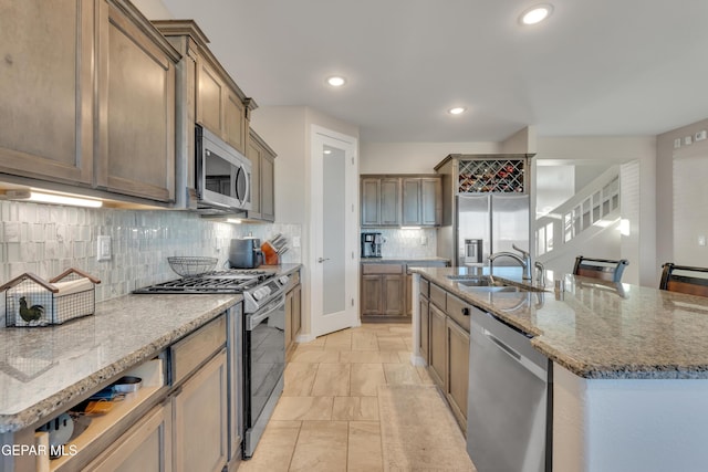 912 Crystal Deer Dr, El Paso, TX 79928 - kitchen featuring appliances with stainless steel finishes, tasteful backsplash, stone countertops, an island with sink, and recessed lighting