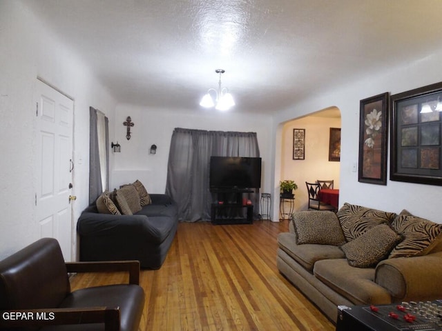 living room featuring hardwood / wood-style flooring and an inviting chandelier