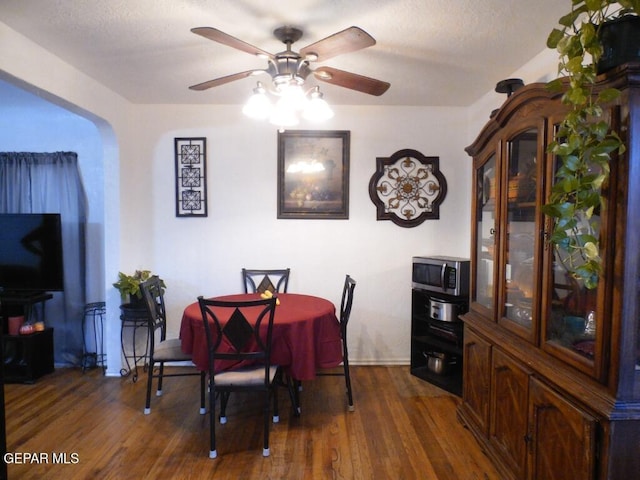 dining room with dark hardwood / wood-style floors, ceiling fan, and a textured ceiling