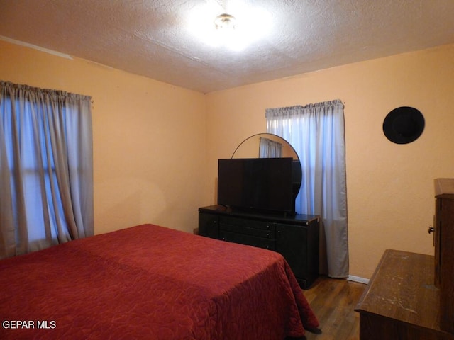 bedroom featuring dark hardwood / wood-style floors and a textured ceiling