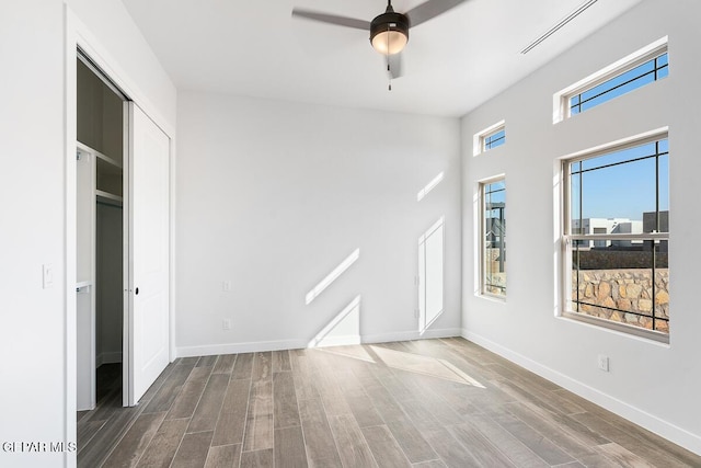 interior space featuring ceiling fan, wood-type flooring, and a closet