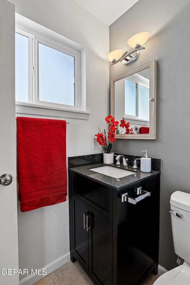 bathroom with tile patterned flooring, vanity, and toilet