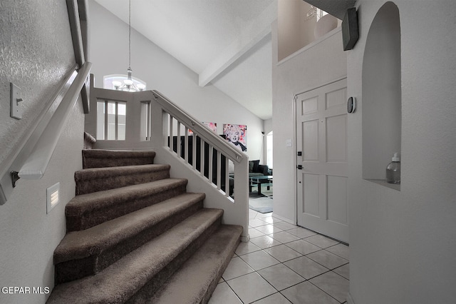 tiled foyer with an inviting chandelier and high vaulted ceiling