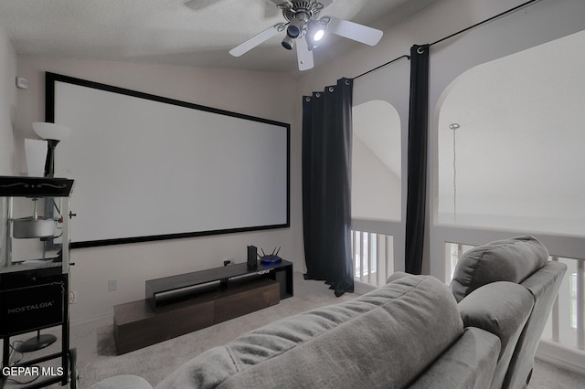 carpeted home theater featuring vaulted ceiling, a textured ceiling, and ceiling fan