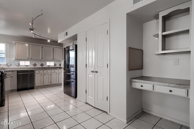 kitchen featuring white cabinetry, backsplash, black dishwasher, light tile patterned flooring, and stainless steel fridge with ice dispenser