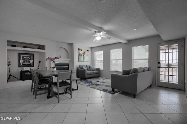 living room with light tile patterned floors, plenty of natural light, and a tile fireplace