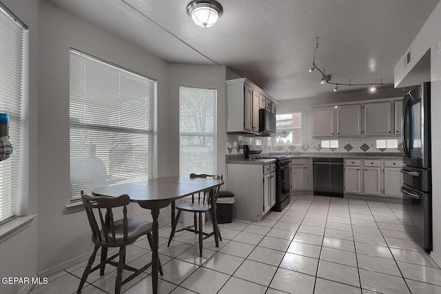 kitchen with tasteful backsplash, light tile patterned floors, and black appliances