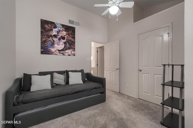 living room with light colored carpet, ceiling fan, and a high ceiling