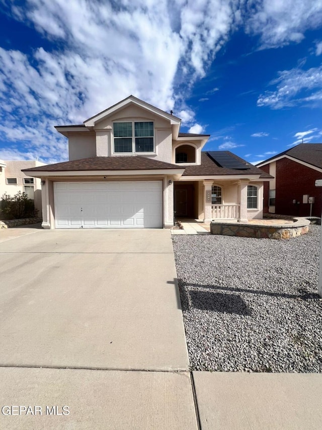 view of front of property with a garage and solar panels