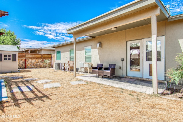 back of house featuring a patio area, central AC unit, and a storage shed