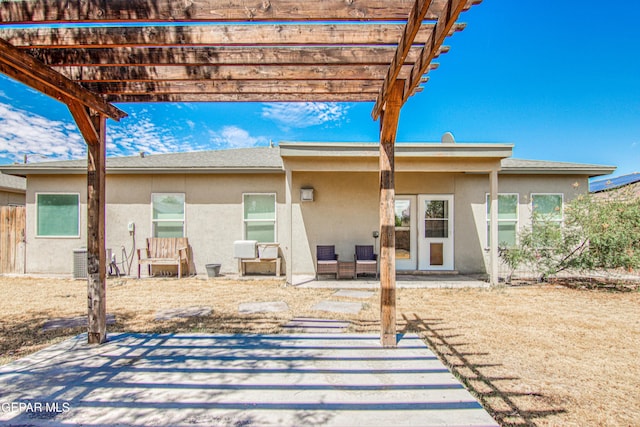 rear view of property featuring a pergola and a patio area