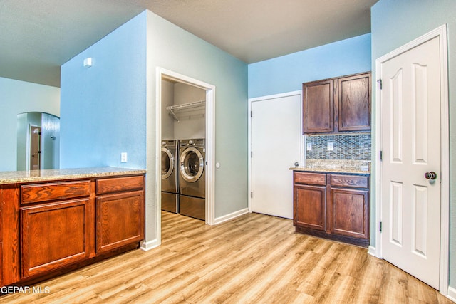 kitchen featuring light wood-type flooring, separate washer and dryer, and backsplash