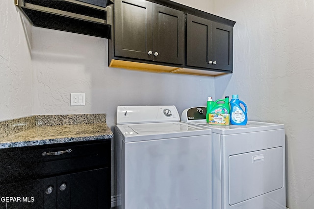 washroom featuring cabinets and washing machine and dryer