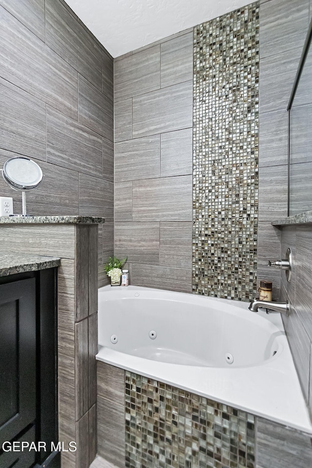 bathroom with tile walls and tiled tub