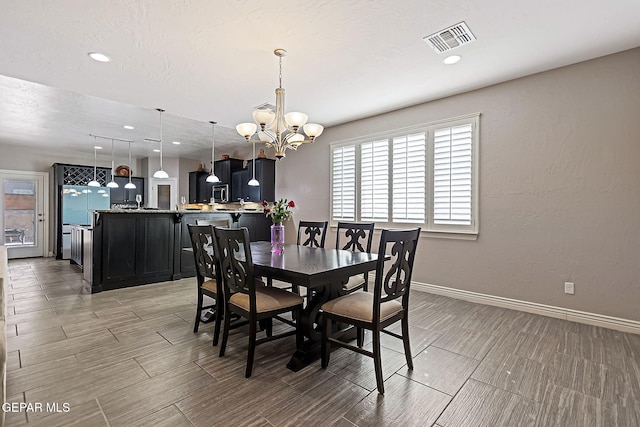 dining area with light hardwood / wood-style flooring and an inviting chandelier