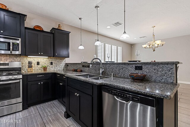 kitchen featuring a notable chandelier, decorative light fixtures, sink, and appliances with stainless steel finishes