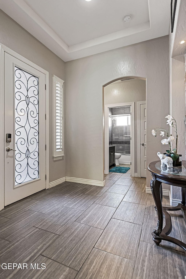 foyer entrance with hardwood / wood-style flooring and a tray ceiling