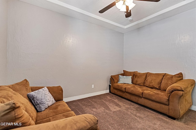 living room featuring ceiling fan and dark carpet