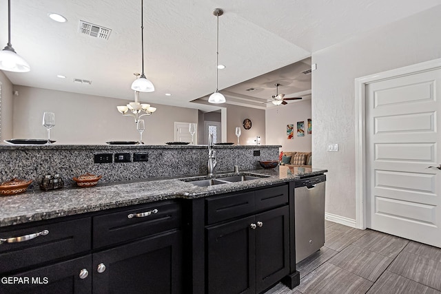 kitchen with ceiling fan, sink, dishwasher, hanging light fixtures, and dark stone counters