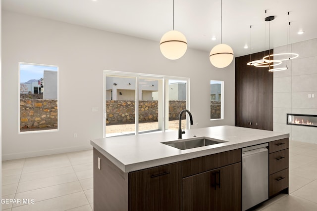 kitchen featuring dishwasher, sink, hanging light fixtures, and a center island with sink