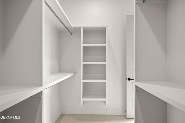 walk in closet with light tile patterned floors