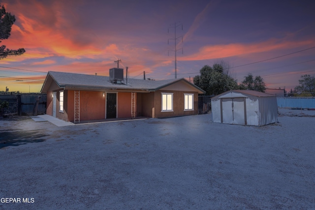 view of front of property with cooling unit and a shed