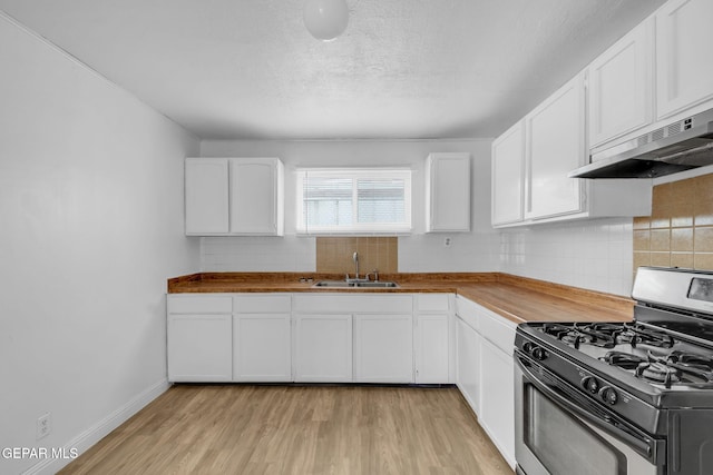 kitchen featuring sink, butcher block countertops, light hardwood / wood-style flooring, stainless steel gas range, and white cabinets