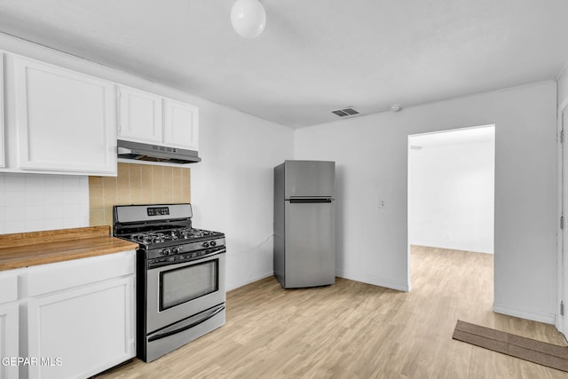 kitchen featuring wood counters, tasteful backsplash, light hardwood / wood-style flooring, stainless steel appliances, and white cabinets