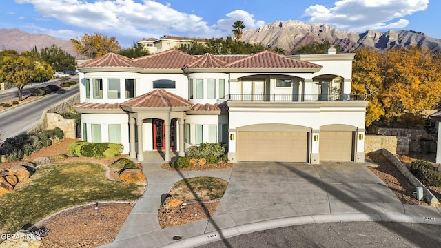 mediterranean / spanish-style home with a mountain view, a balcony, and a garage