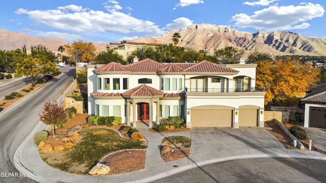 view of front of property with a mountain view, a balcony, and a garage