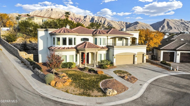 mediterranean / spanish home with a mountain view, a balcony, and a garage