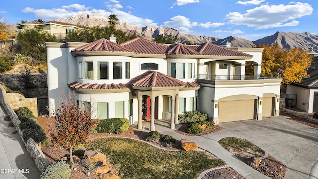 mediterranean / spanish home with a mountain view, a garage, and a balcony