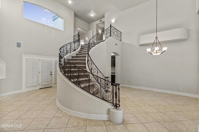 stairs featuring tile patterned flooring and a high ceiling