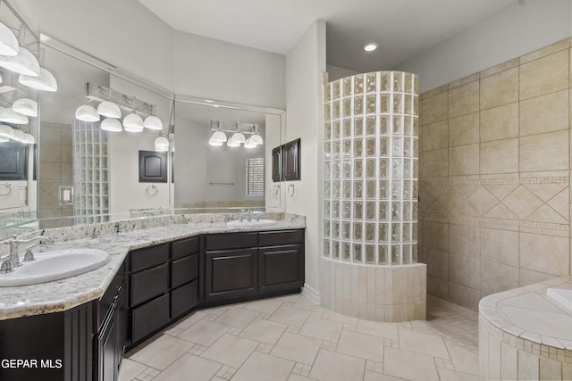 bathroom with a tile shower and vanity