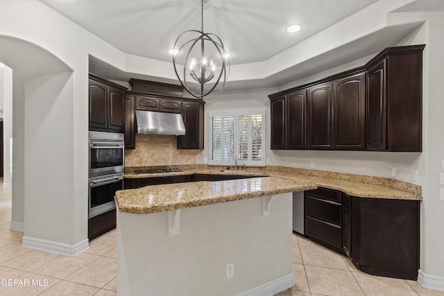 kitchen featuring a center island, decorative light fixtures, dark brown cabinets, and appliances with stainless steel finishes