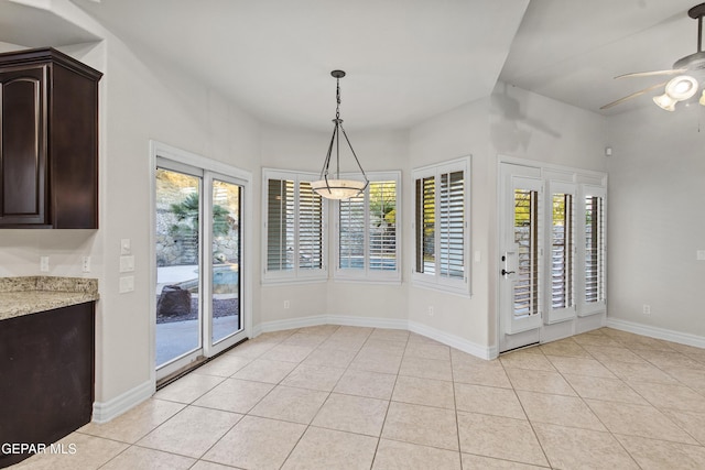 unfurnished dining area with ceiling fan and light tile patterned flooring