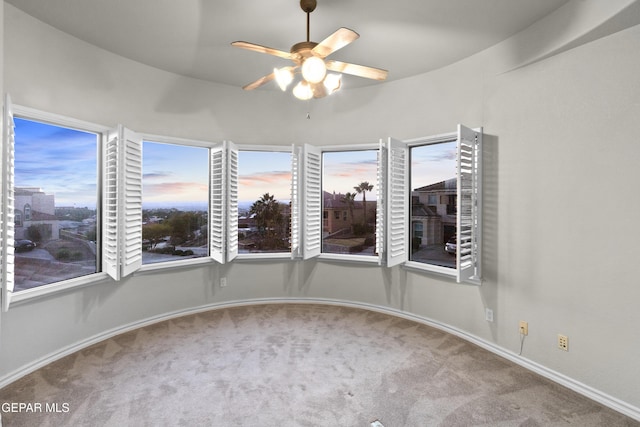 spare room featuring ceiling fan and carpet