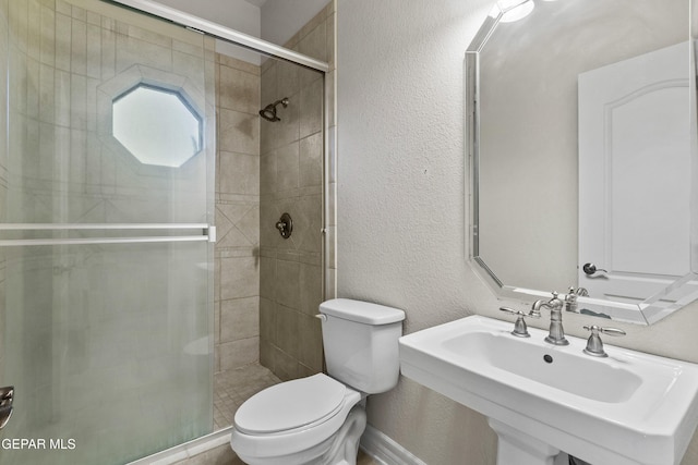 bathroom with walk in shower, sink, and toilet