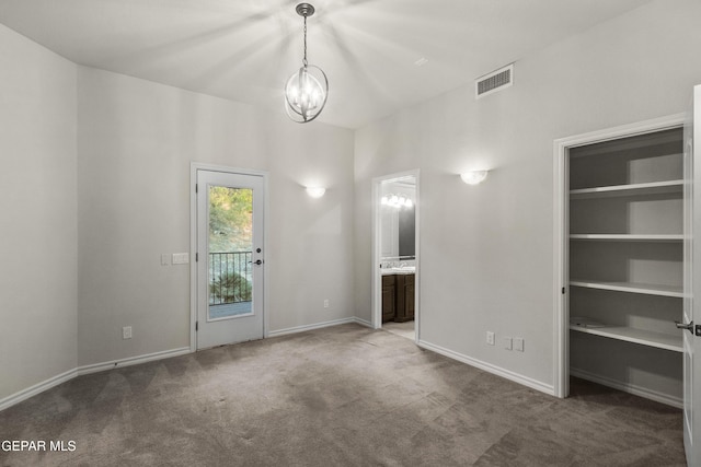 unfurnished living room featuring carpet and an inviting chandelier