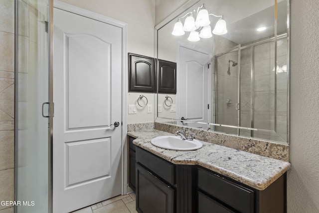 bathroom featuring tile patterned floors, vanity, a chandelier, and an enclosed shower