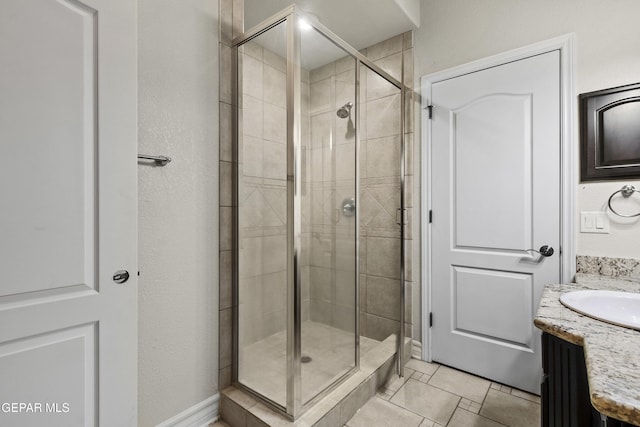 bathroom with tile patterned floors, vanity, and a shower with shower door