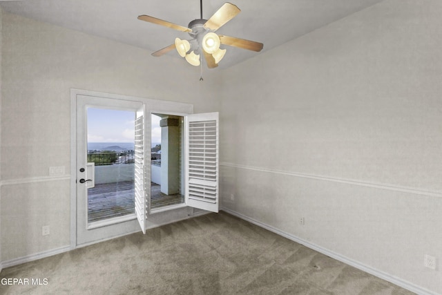 carpeted spare room featuring ceiling fan