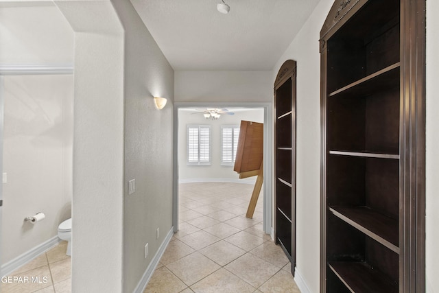 hallway featuring light tile patterned flooring and a textured ceiling